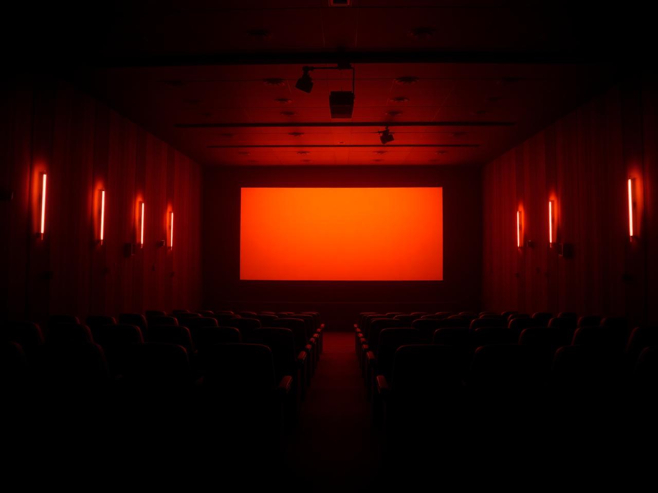 Dark cinema hall with a glowing screen
